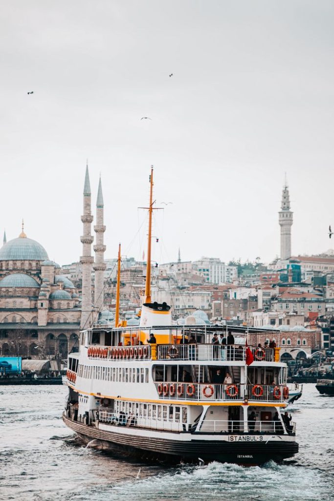 Scenic view of a ferry crossing the Bosphorus with Istanbul's historic skyline in the background.